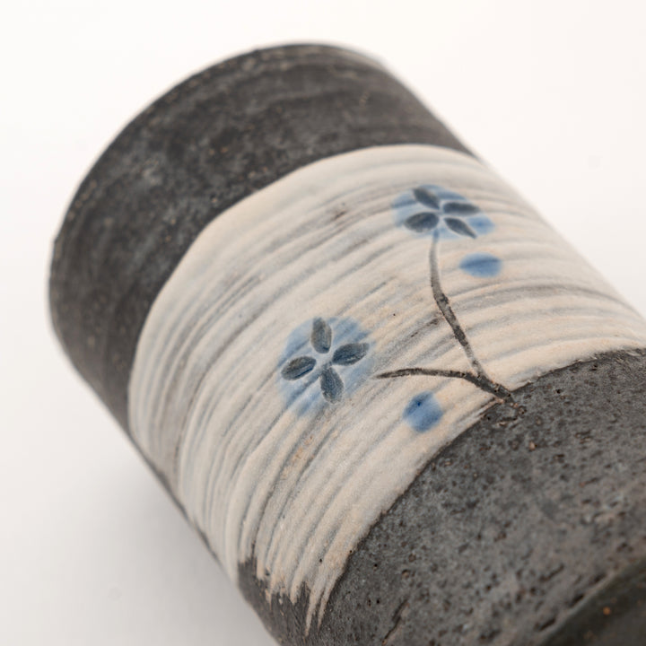 Close-up detail of blue floral Shigaraki mini vase with charcoal pottery texture