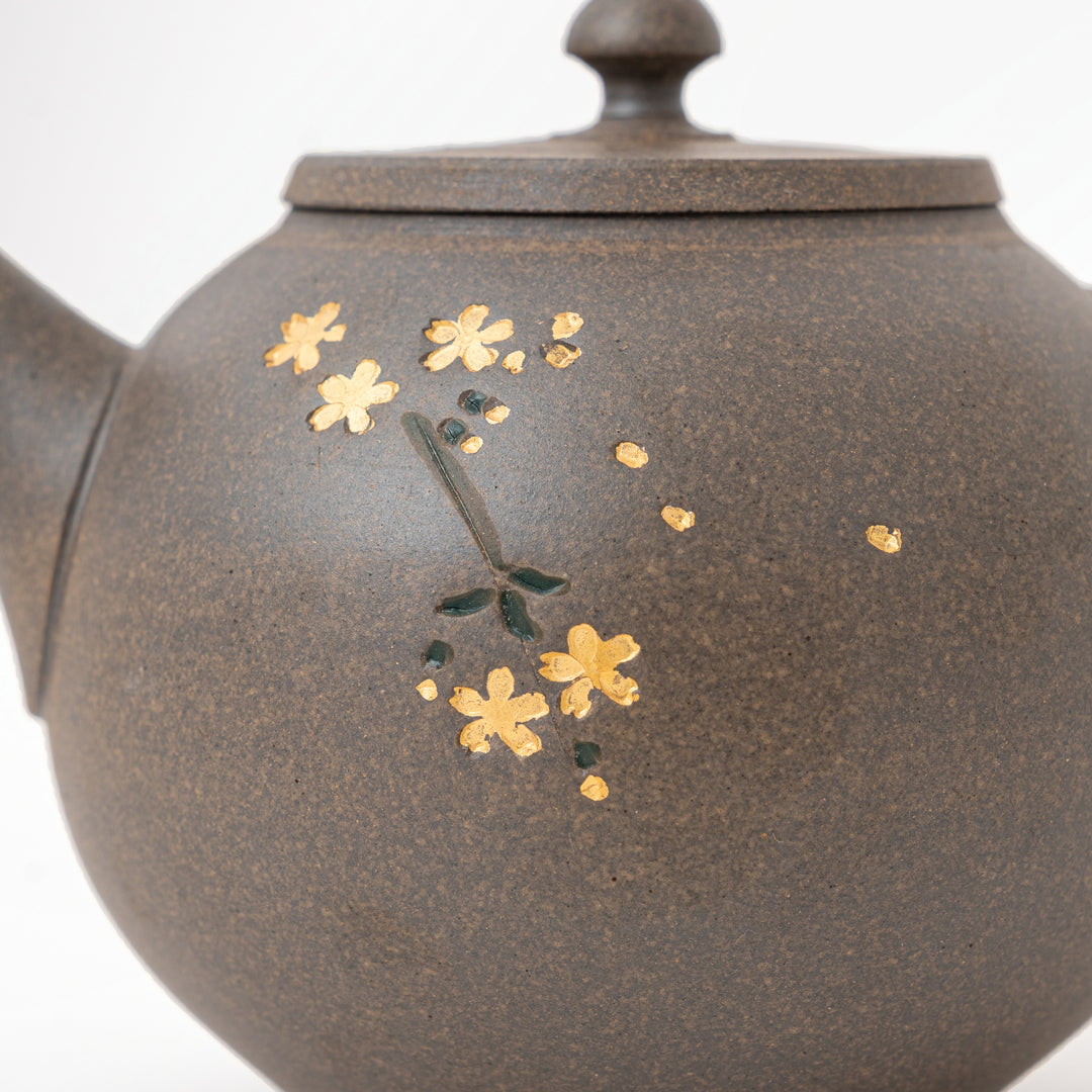 Traditional Japanese kyusu with textured fired clay and floral details