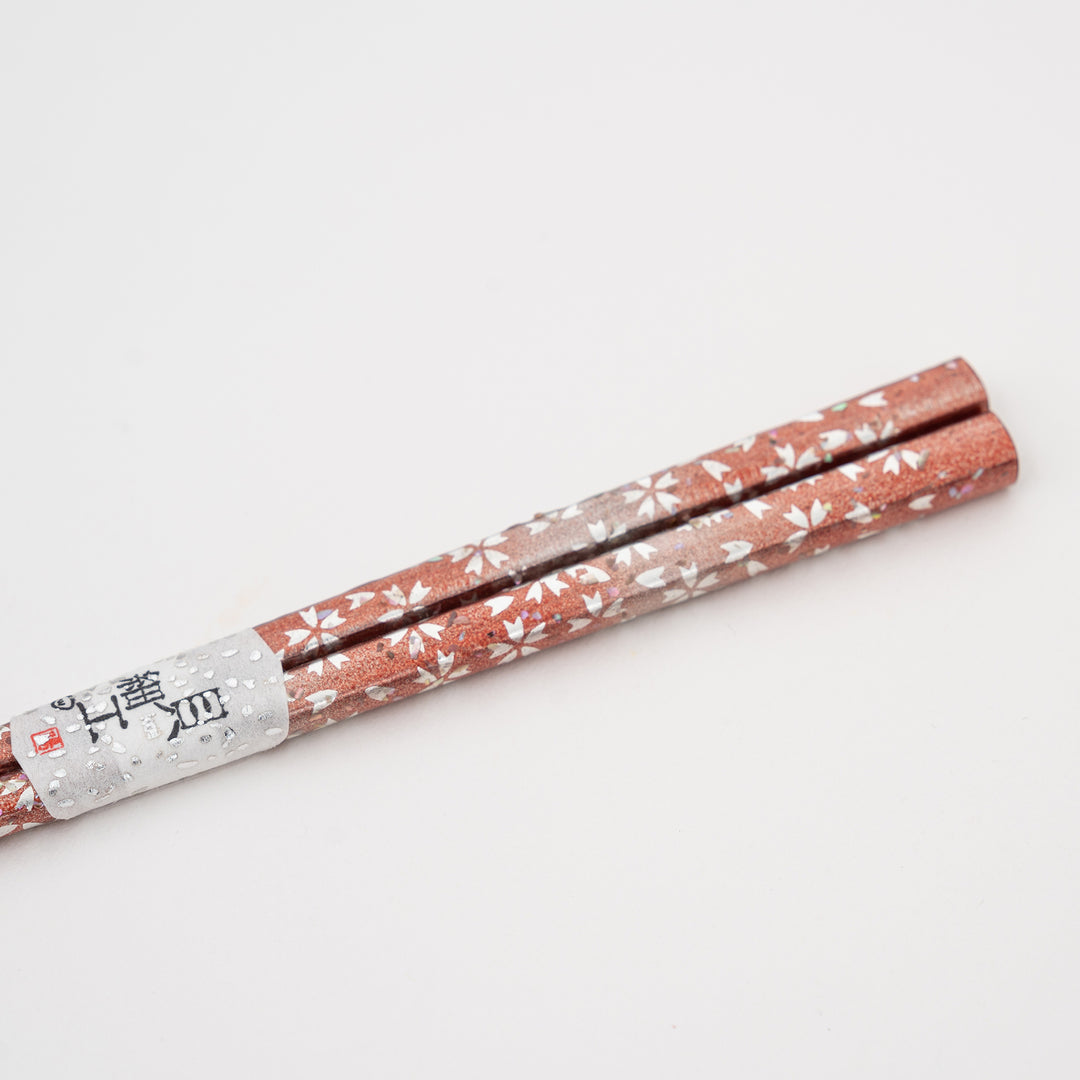 A full view of a pair of handcrafted Japanese chopsticks, showcasing the complete design and shimmering Raden inlay.