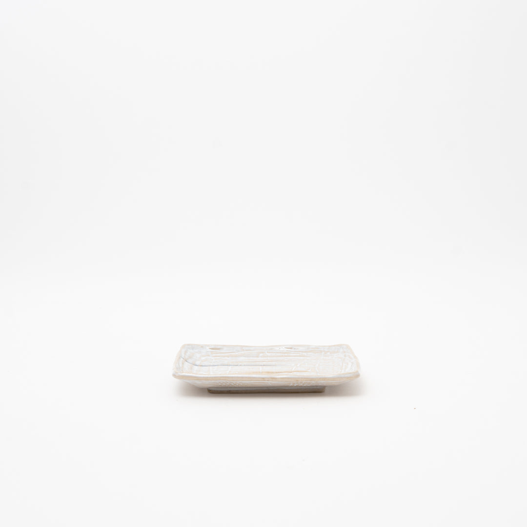 Japanese rectangular ceramic plate with hand-textured wave pattern surface in cream white glaze