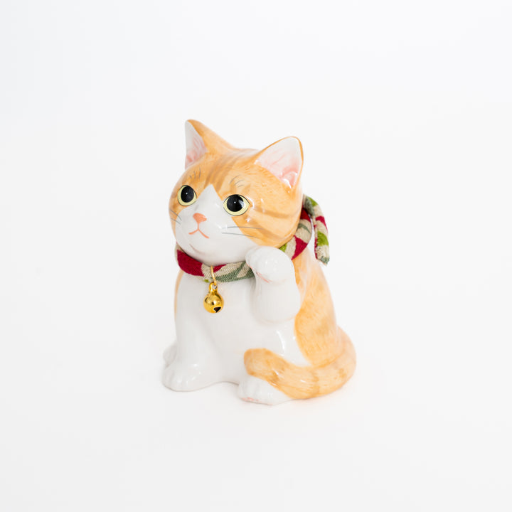 Cat-shaped decorative item with a bell on a white background
