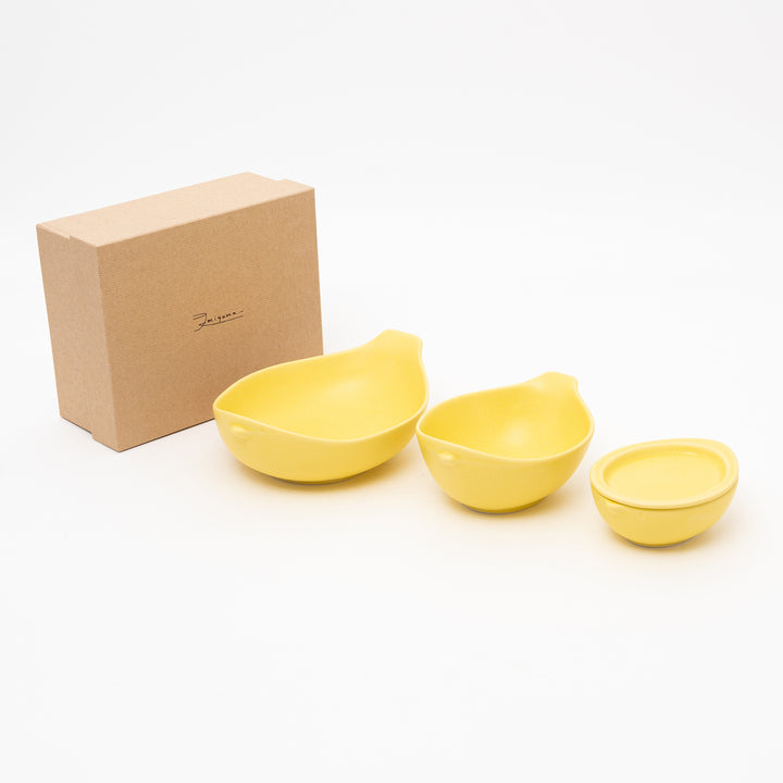 4-piece lemon yellow ceramic bowl set in a gift box, featuring bird or teardrop shapes, including two large bowls, a small bowl, and a lid.