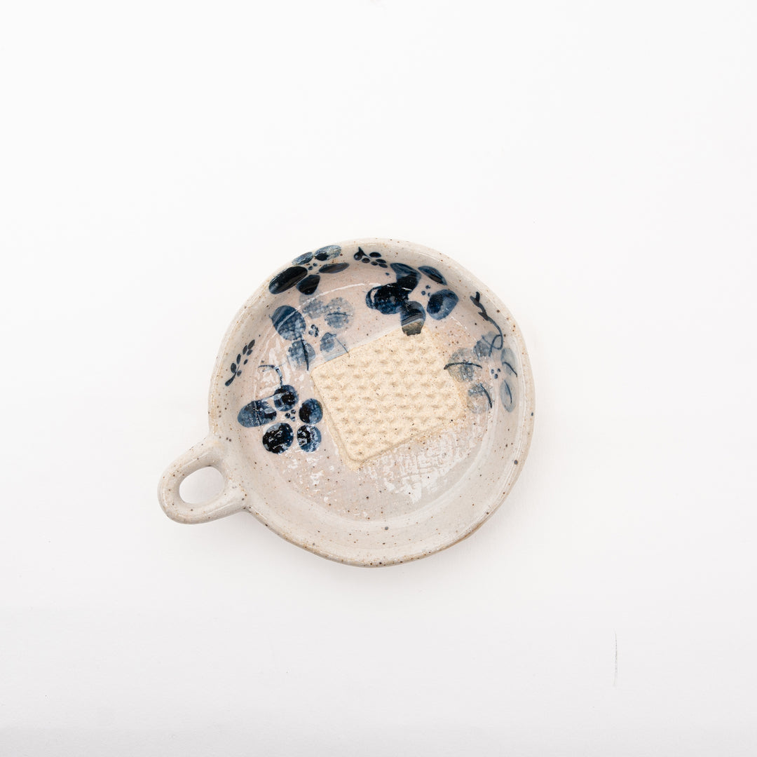 Close-up view of the hand-painted indigo flower on a grater