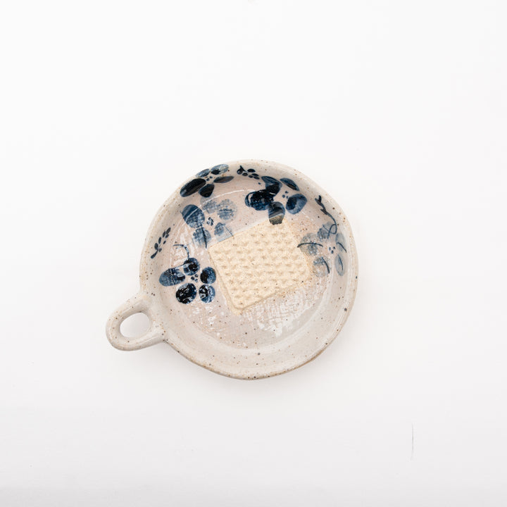 Close-up view of the hand-painted indigo flower on a grater