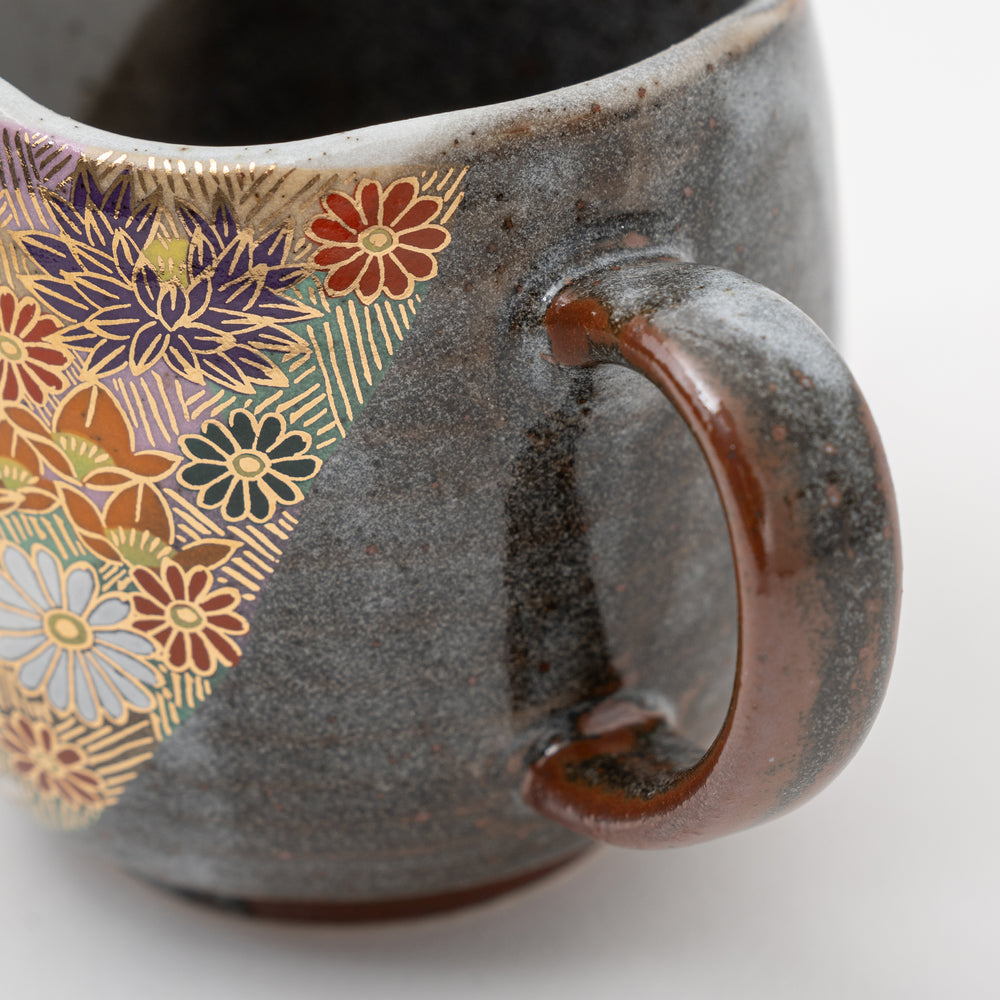 Close-up of hand-painted Hanazume flowers with gold accents on a Kutani Ware mug.